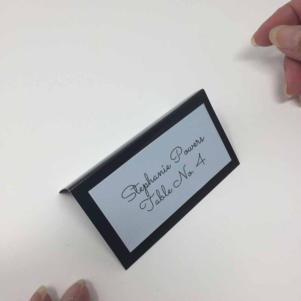 Black place card with pastel blue label applied.